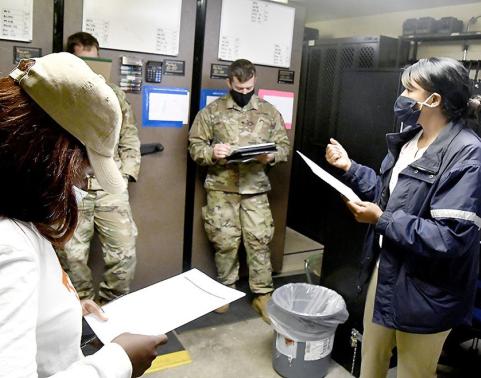 A physical security supervisor walks new armorers through an arms room inspection checklist during a March 2021 training session at Fort Polk, Louisiana.