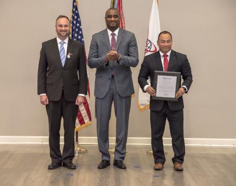 Outgoing CHESS Product Lead (PL) Doug Haskin (left) and ES Project Director Lee James III (center) present the CHESS charter to incoming CHESS PL Wayne Sok (right). (U.S. Army photo by Laura Edwards, PEO EIS)