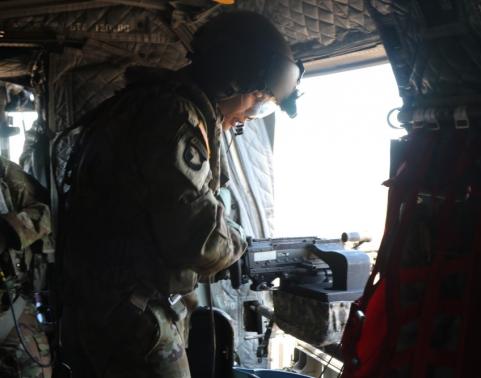 Soldier firing machine gun from helicopter