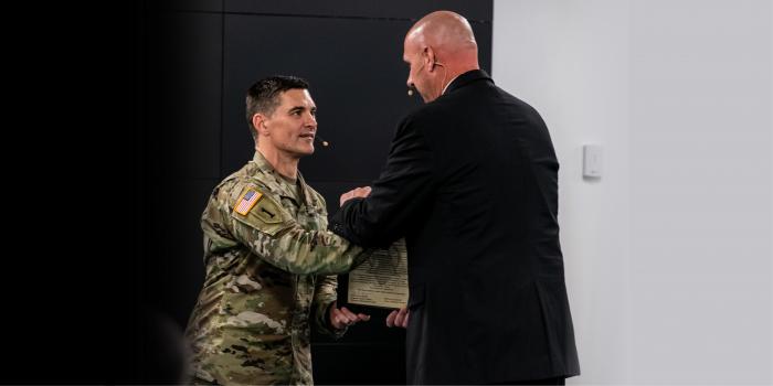 Col. Jay Shell hands the P2E charter to incoming product manager Tom Dunaway at a change of charter ceremony June 25 at Fort Belvoir.