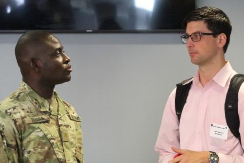 Maj. Peter Amara (left), APM for Cyber Analytics, discusses Collaboration Day with an industry representative. Maj. Amara hosted the final Collaboration Day on August 9, 2018.