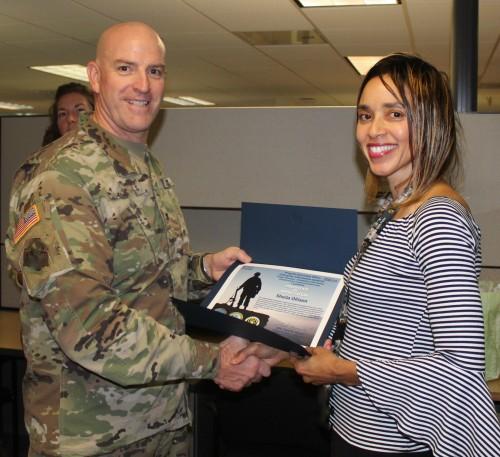 Col. Harris presents civilian employee with certificates of appreciation