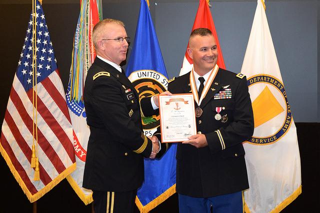 Two soldiers hold certificate.