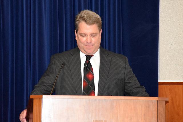 Man speaks at podium.