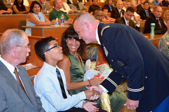 Soldier shakes boy's hand.