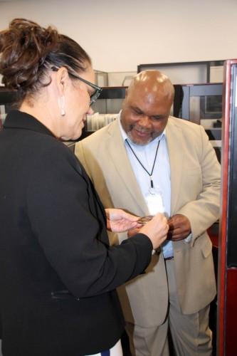 Program Executive Officer Enterprise Information Systems (PEO EIS) Ms. Chérie Smith presents Mr. Larry Skinner, the Logistics Modernization Program (LMP) Sales and Distribution Functional Team Lead, with a PEO EIS coin to commemorate his 34 years of government service.