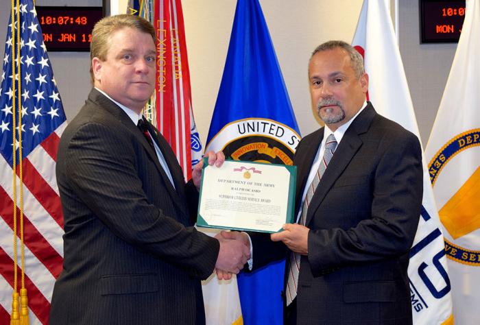 Two men hold a certificate at ceremony.